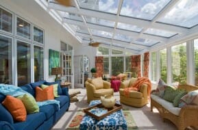 All-glass sunroom with comfy furnishings and lots of natural light