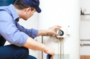 plumber flushing and draining a hot water heater