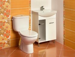 White floor-mounted toilet in an orange bathroom