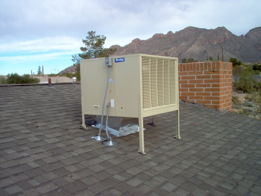 Swamp cooler installed on roof with mountains in the back 