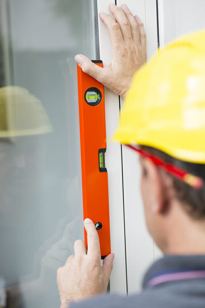 A contractor leveling a window 
