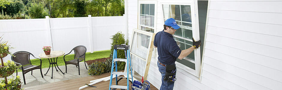 A contractor installs a window into a home 