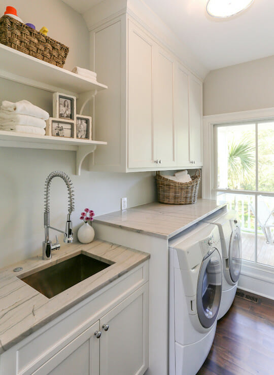 Laundry Room with white appliances, cabinets, and shelves, including a sink and flat top for folding