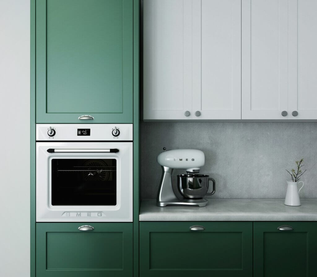 A small wall oven installed in a kitchen with green and white cabinets