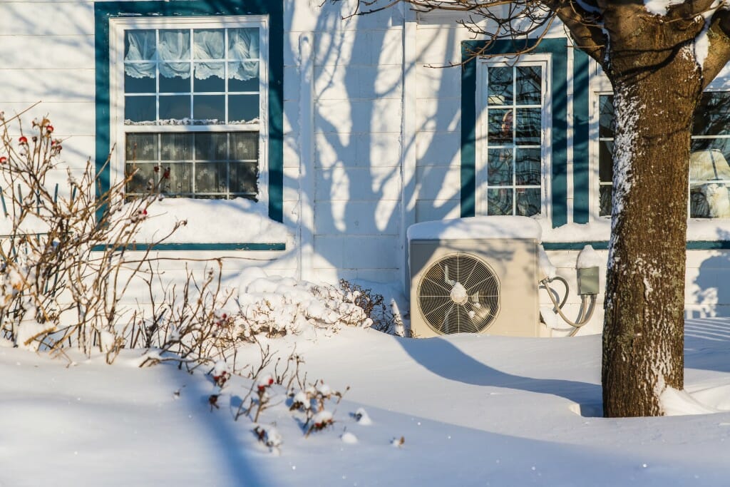 An external heat pump on a snowy day