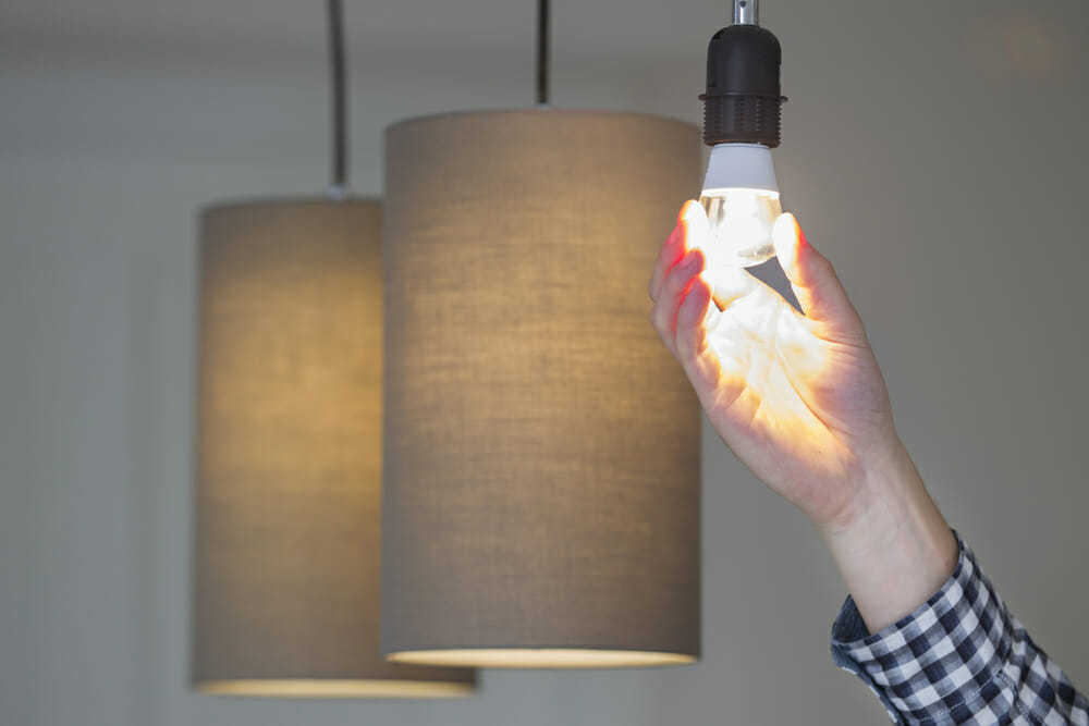 Screwing a new LED bulb into pendant lights