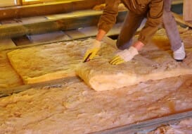 Contractor cutting insulation for attic