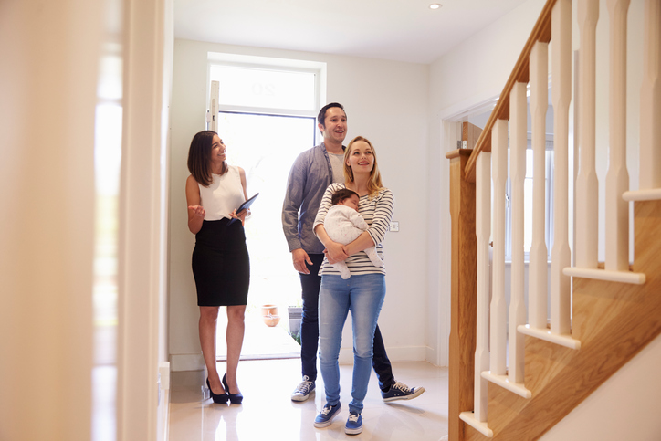 Realtor Showing Young Family Around Property For Sale