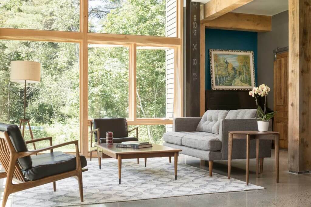 A living room with large wood-framed Marvin picture windows