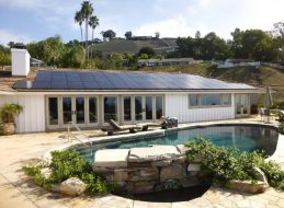 Solar panels on a home viewed from the backyard with a pool