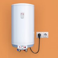 Tank water heater installed on an orange wall