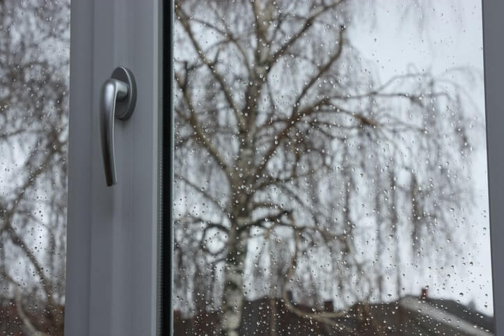 Casement storm window with a rain storm visible outside