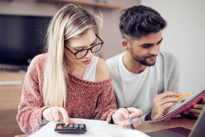 Close-up image of a young couple comparing HVAC financing offers and creating a budget