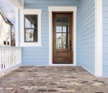 Exterior photo of a home showing the front door, front porch, and light blue siding