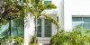 Luxury modern entrance architecture of house in Florida city island on travel, sunny day, property real estate with garden landscaping decoration, green glass windows