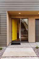 Picture of a yellow front door standing open next to a picture window