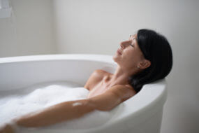 Relaxed lady in her forties relaxing in a modern soaking tub