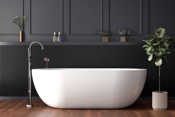 Modern freestanding tub with a floor mounted faucet in a black bathroom