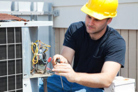 Contractor fixing an industrial air conditioning compressor.