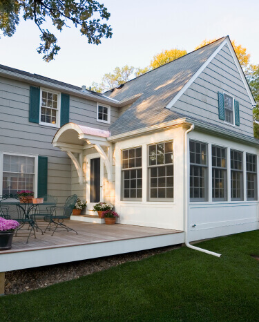 Windows installed on a home with vinyl siding and teal shutters