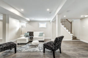 Home basement with light floors, wood staircase, and egress windows
