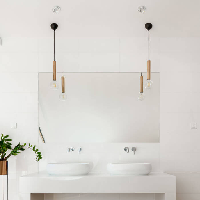 Image of a modern, sleek bathroom vanity with gold pendant lighting