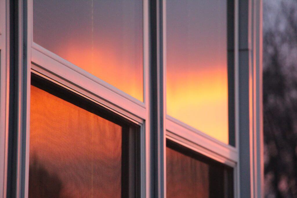 Sunset reflected in a home's glass windows