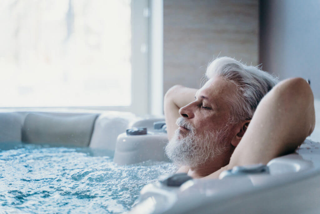 Adult man relaxing in a modern walk-in tub with hydrotherapy