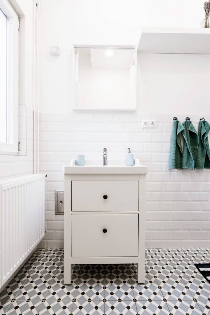 Small bathroom with black, white, and gray floor tile