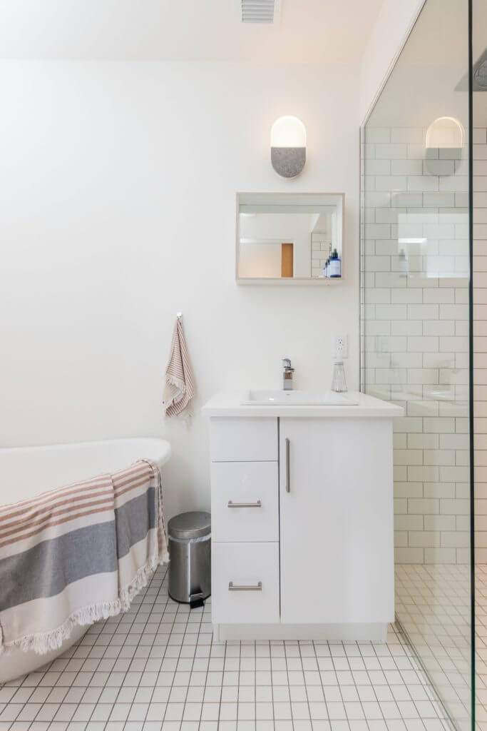 monochromatic small, white bathroom with tile floors, tiled shower floor, and tiled shower wall