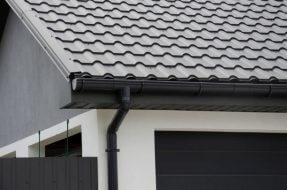 Black plastic gutter system and metal tiles on the roof