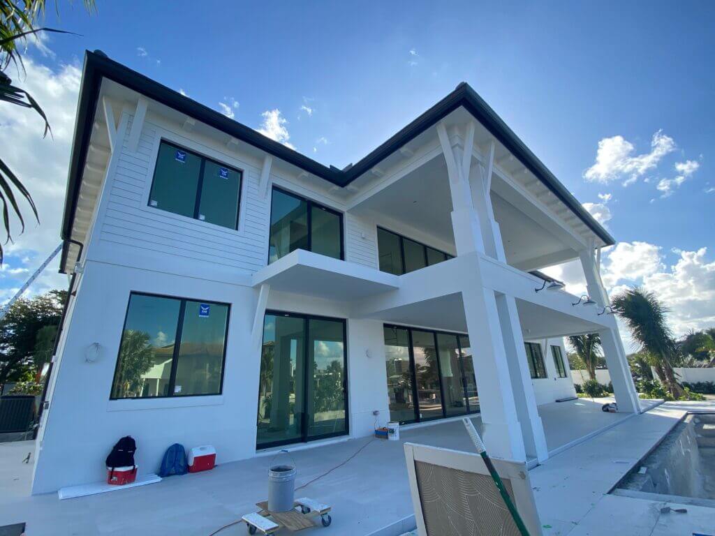 A new construction home painted white with black gutters