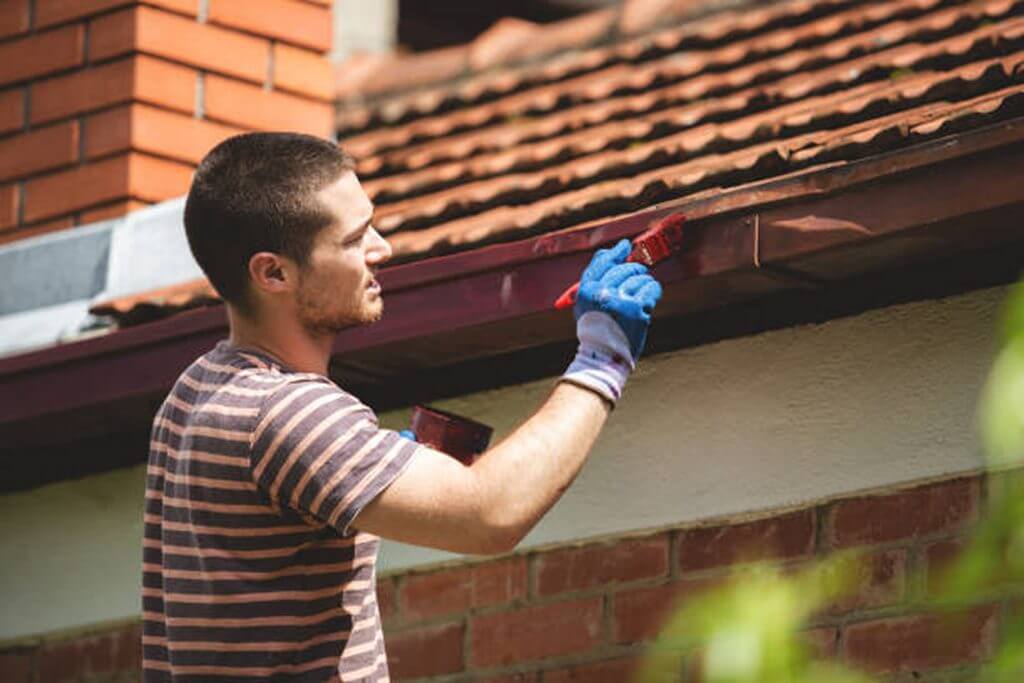 a man painting metal gutters