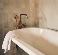 black freestanding bathtub with bronze faucet