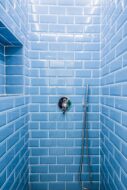 Shower tiled with blue subway tiles