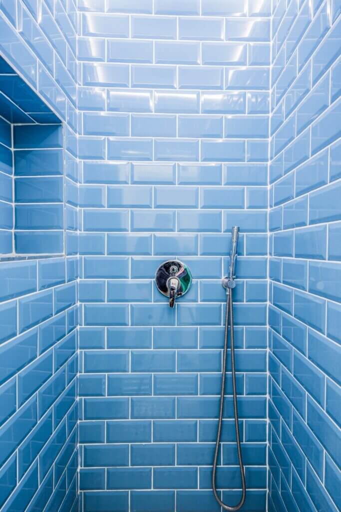 Shower tiled with blue subway tiles