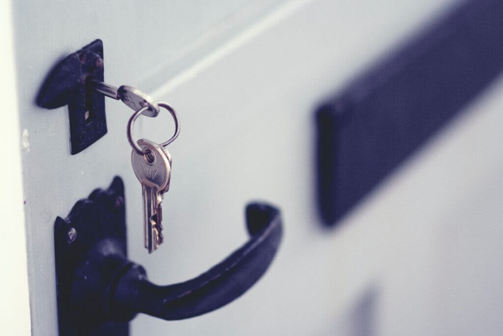 Set of keys unlocking a door implying a home security system