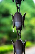 Image shows a closeup view of a gutter rain chain.