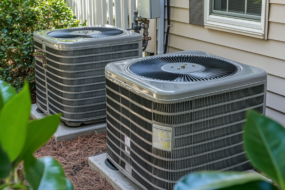 two central ac system units in the back of a home
