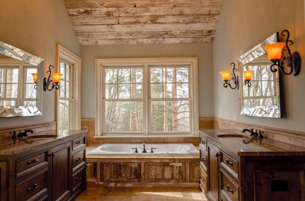 Drop in tub with wood surround in a bathroom, installed under single-hung windows