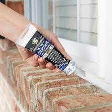 Close-up image of a person applying silicone window sealant, linking to product on homedepot.com