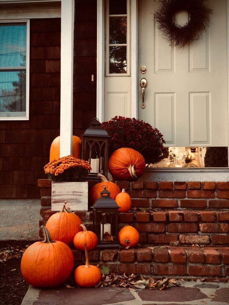 Image of pumpkins on the brick steps leading up to a front porch