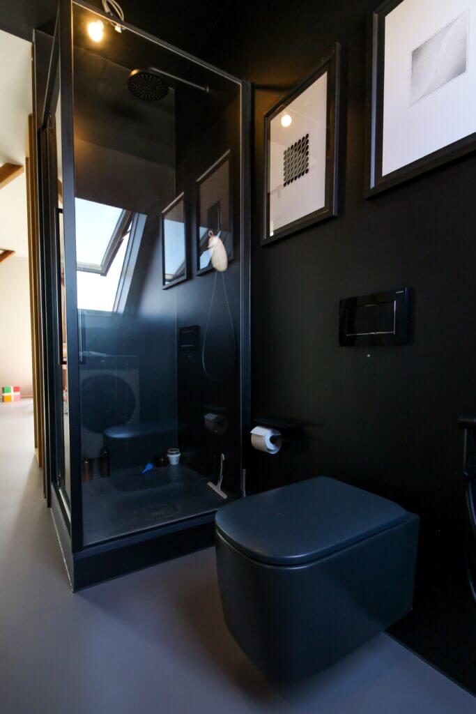 All black bathroom with framed corner shower