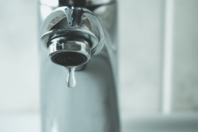Close-up image of a dripping faucet requiring plumbing repair