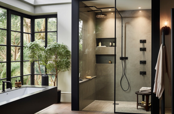Moody black-framed walk-in shower in bathroom with additional black elements