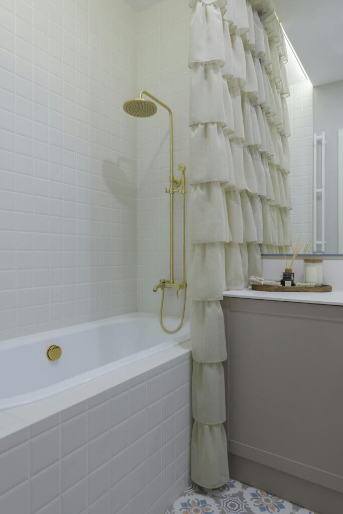White and gray alcove drop-in tub with gold shower