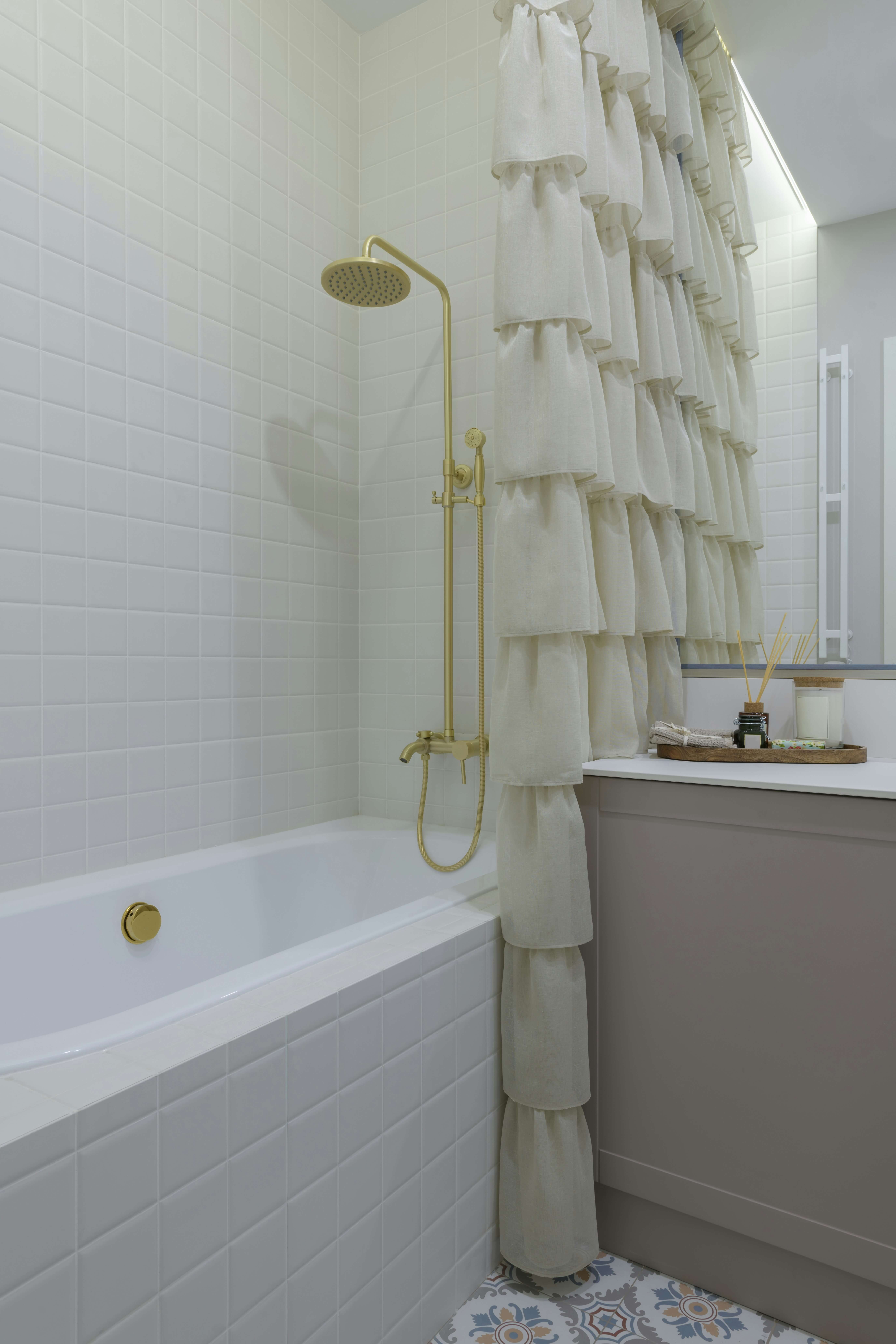 White and gray alcove drop-in tub with gold shower
