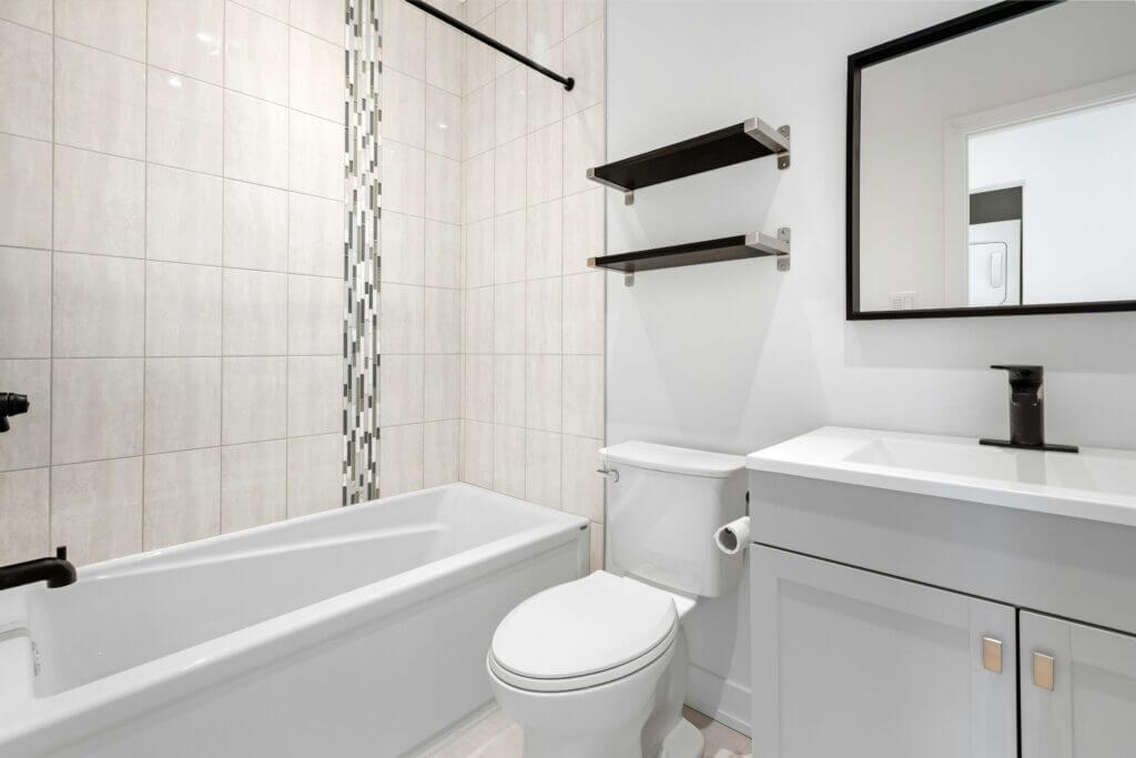 A bathtub shower combo in a light colored, updated bathroom