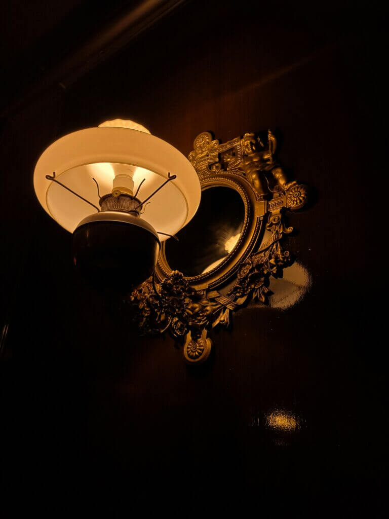 Single, elegant sconce installed with a frame and amber lighting