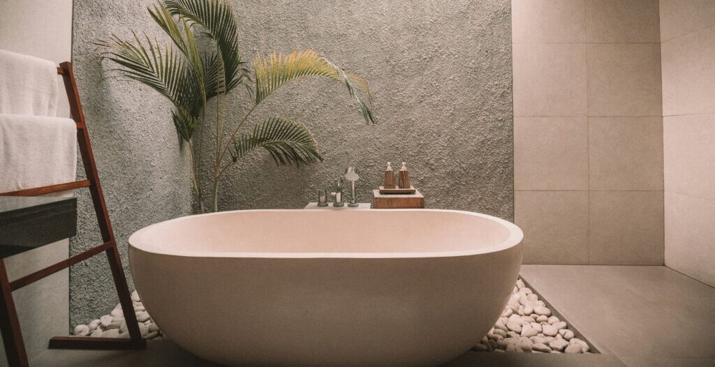 A stone bathtub in an earthy bathroom
